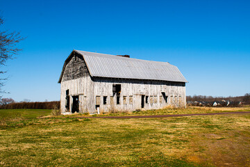 Obraz premium Large wooden barn in field, part of civil war Battle of Chancellorsville