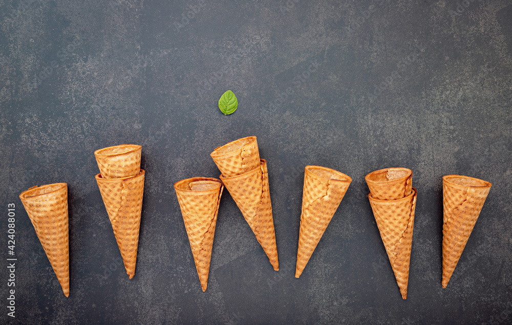 Poster flat lay ice cream cones collection on dark stone background . blank crispy ice cream cone with copy