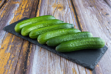 Green cucumbers on wooden background