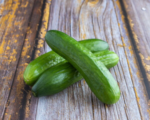 Green cucumbers on wooden background