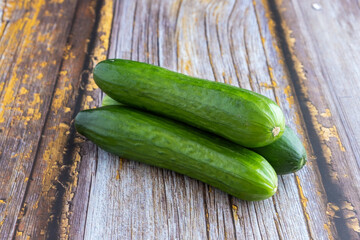 Green cucumbers on wooden background