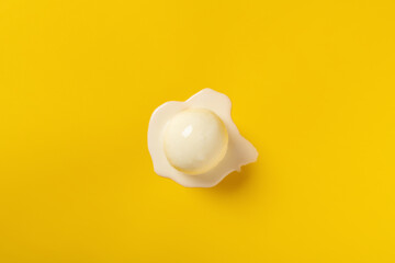 top view vanilla flavor ice cream ball in a melting process on yellow background