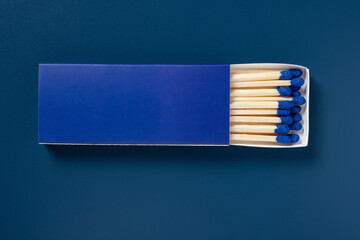 blue matchbox and blue match sticks on a black background