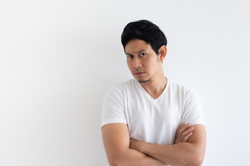 Serious and upset Asian man wears white t-shirt isolated on white background.