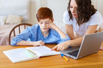 Fototapeta na wymiar Mom helps her son with online homework. Close-up photo.