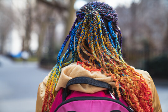 Young woman bright vivid colorful afro braids dreadlocks hairstyle. Teenager funky beauty fashion style.