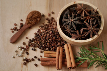 Anise and spices in a wooden cup with black background, industrial concept