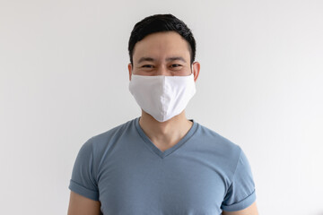 Happy and pleased expression of Asian man in white mask on isolated background.