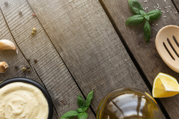 Cooking homemade mayonnaise, garlic cream sauce. Seasonings on wooden background