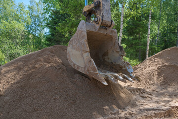 excavator digs clay soil at the construction site