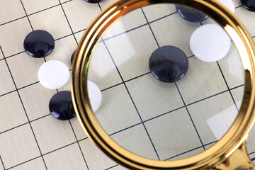 Black chess pieces under the magnifying glass