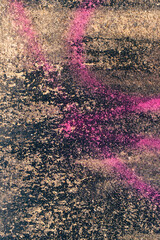 Pink graffiti on moss and concrete