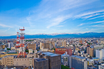Toyama cityscape and Tetayama mountain range (Japan alps) views from Kasui park in Toyama city, Toyama, Japan.