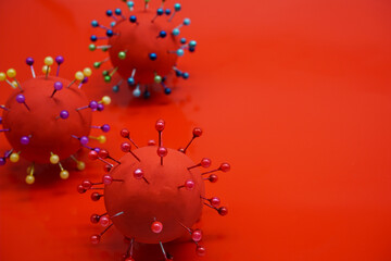 Virus model made of plasticine on a red background.