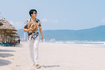 Young Asian man walking on the beach
