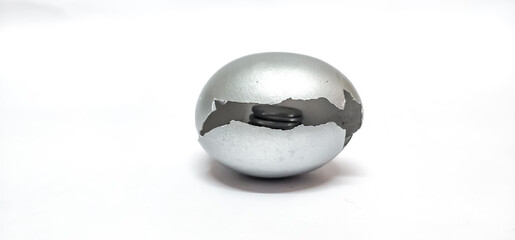 Closeup of broken Silver Egg shell isolated in a White background with selective focus and copy space symbolizing the concept of retirement money, investment , savings , pension , fixed deposit.