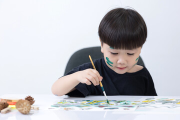 Happy little Asian kid at the table draw with water color Learning and education of kid.