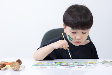 Happy little Asian kid at the table draw with water color Learning and education of kid.