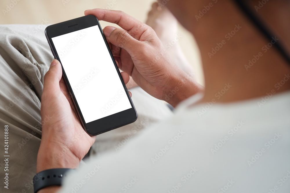 Poster close up view of man sitting on sofa and using mobile phone. blank screen for advertise text.