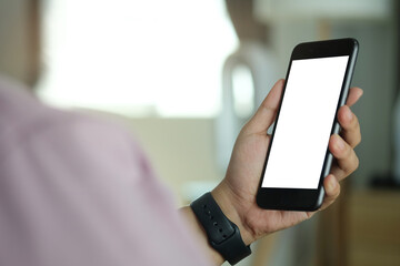 Close up view of man sitting on sofa and using mobile phone. Blank screen for advertise text.