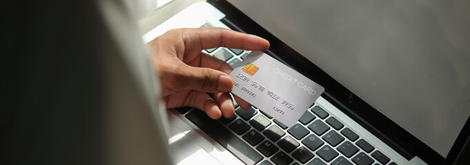 Close up view of man holding credit card. Online shopping or online payment.