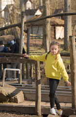 Girl walks on a log in the park