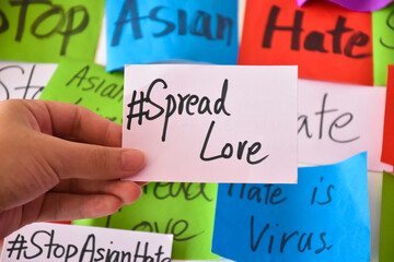 Word card '#SpreadLove.' holding in hand, concept for calling all people around the world to stop...