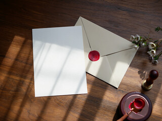 Envelope back side with red wax seal and blank card invitation Mockup. Top view on wooden...