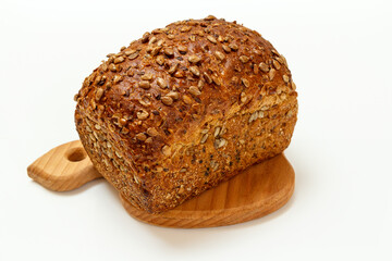 Loaf of bread on wooden cutting board on white background