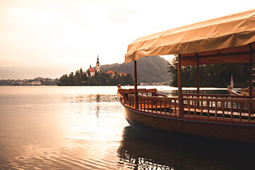 Lake Bled Slovenia. Beautiful mountain lake with small Pilgrimage Church. Traditional wooden boats...
