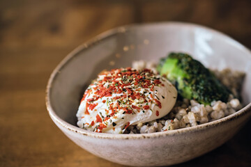 Healthy vegetarian salad. Warm buckwheat groats, poached egg and avocado sauce close-up. Selective focus