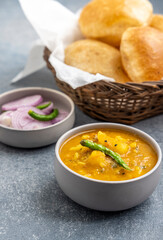 Masala Aloo Sabzi or Indian potato gravy served with fried puri or Poori with sliced onion and green chilly 