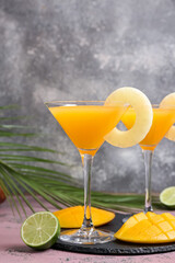 Glasses of tasty mango margarita on grunge background