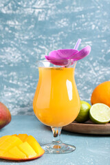Glass of tasty mango margarita on color background