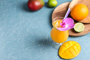 Glass of tasty mango margarita on color background