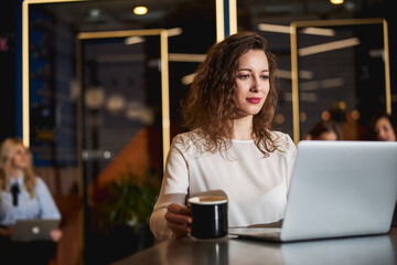 Beautiful young woman working on laptop in office