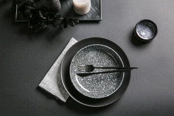 Stylish table setting and candles on dark background