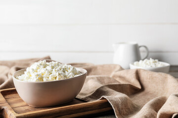 Bowl with cottage cheese on wooden background