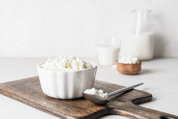 Bowl with cottage cheese on light background