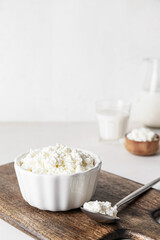 Bowl with cottage cheese on light background