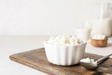 Bowl with cottage cheese on light background