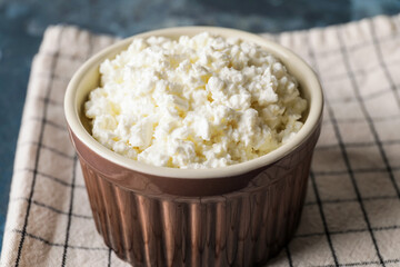 Bowl with cottage cheese on table, closeup