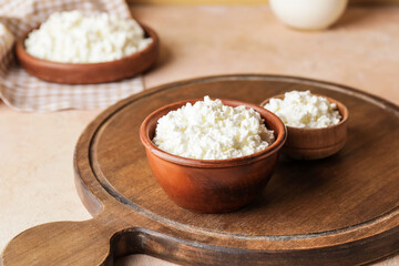 Bowls with cottage cheese on color background