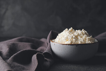 Bowl with cottage cheese on dark background
