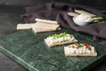 Crispbreads with cottage cheese on dark background