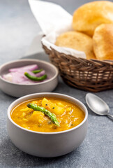 Masala Aloo Sabzi or Indian potato gravy served with fried puri or Poori with sliced onion and green chilly 