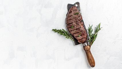 Juicy Beef rump steak from marble beef medium rare served on old meat butcher on light background, Long banner format, top view