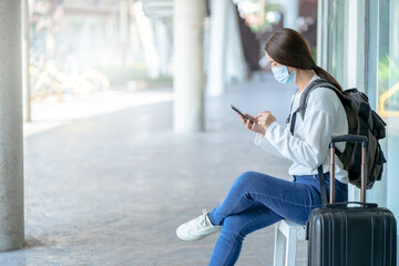 Asian woman tourist wearing protective mask going to travel trip during corona virus covid-19 pandemic..