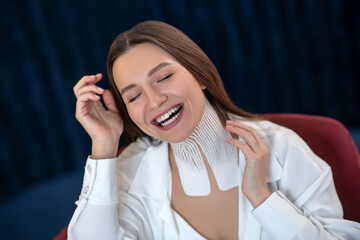 Fototapeta premium Young woman with tapes on her neck sitting on a chair and feeling amazing