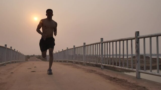 A silhouette of a young man jogging in the evening